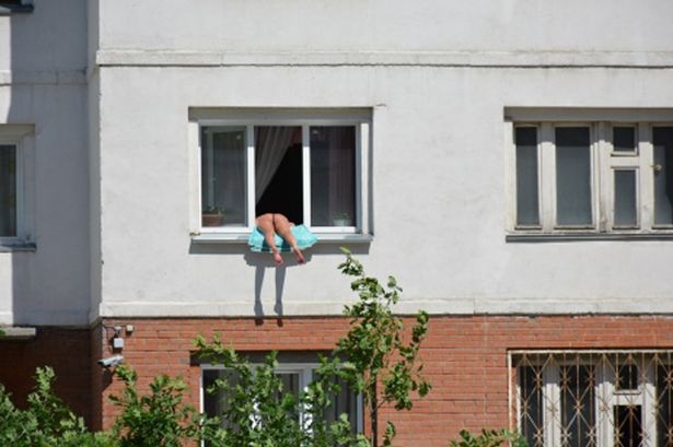 Russia, prende il sole nuda sul davanzale della finestra