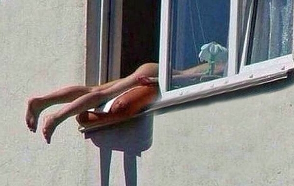 Russia, prende il sole nuda sul davanzale della finestra